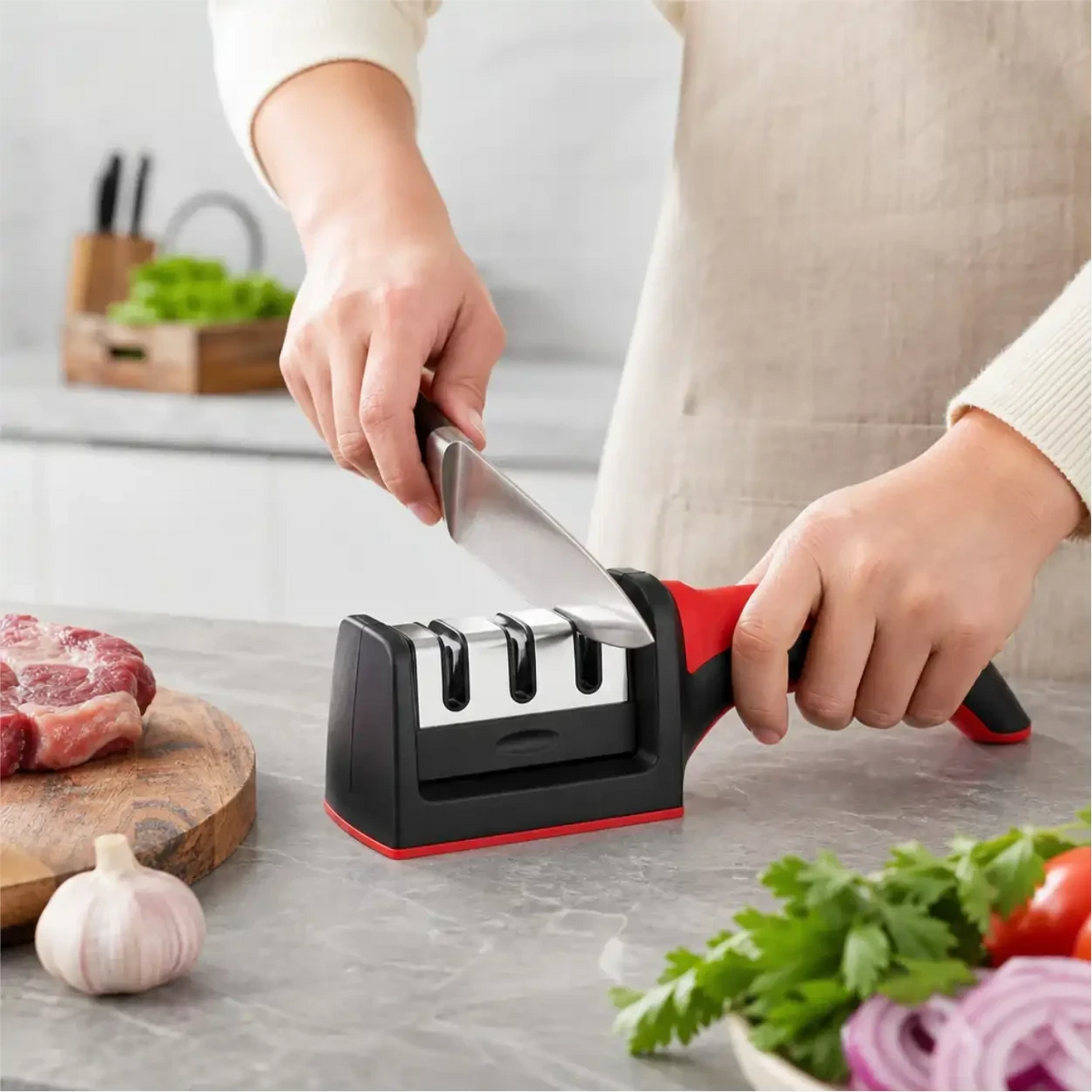 Pessoa utilizando o afiador de facas profissional Decoricasa de 3 estágios com cabo ergonômico vermelho em bancada de cozinha