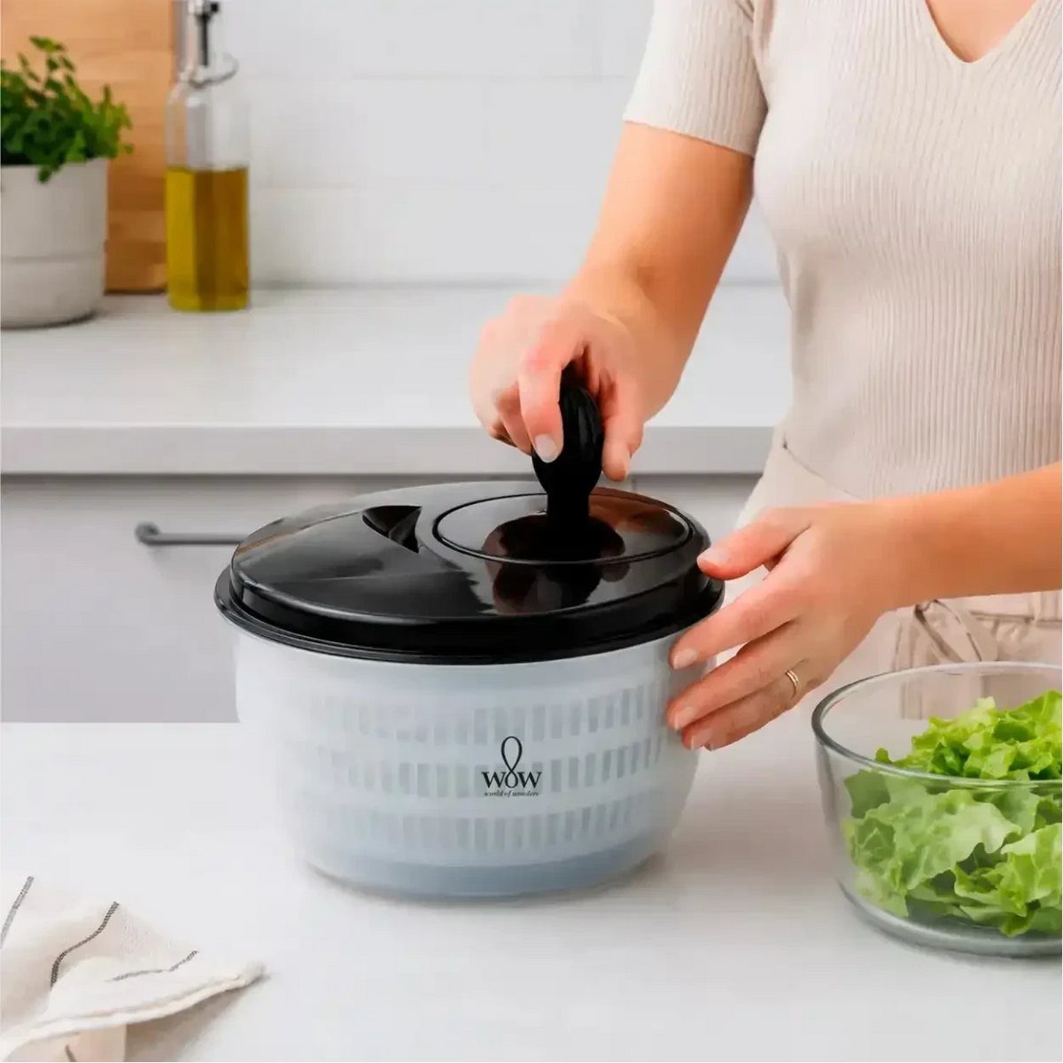 Centrífuga de salada manual Decoricasa de 4 litros com tampa preta e cesto translúcido em bancada de cozinha