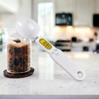 Colher medidora digital Decoricasa branca com visor LCD para pesagem precisa de ingredientes em cozinha moderna.