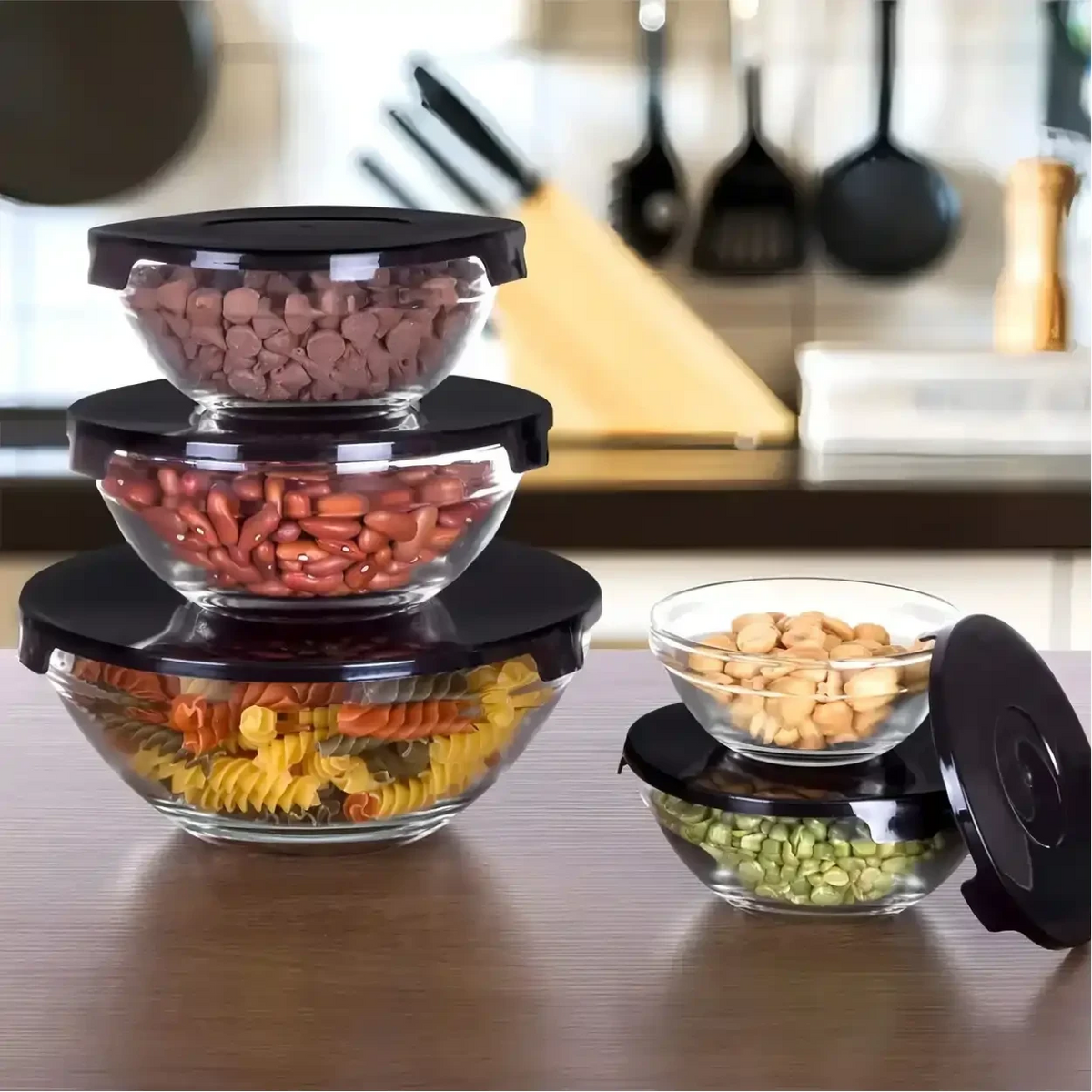 Conjunto de 5 potes de vidro Decoricasa com tampas pretas, organizados em uma bancada de cozinha.