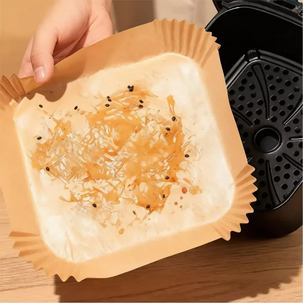 Forma de papel descartável CleanFry Decoricasa com resíduos de gordura sendo removida de uma air fryer
