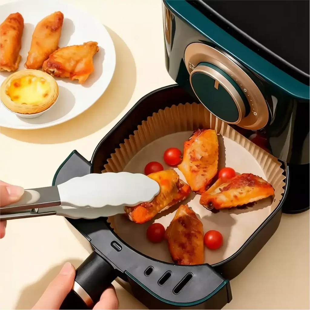 Forma de papel descartável CleanFry Decoricasa dentro de air fryer com asas de frango e tomates cereja