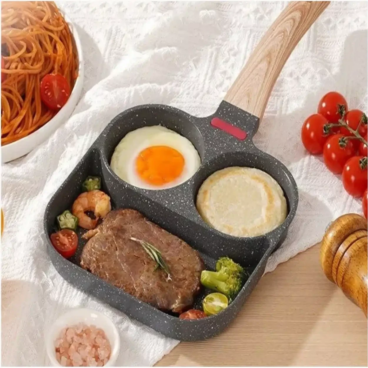Frigideira antiaderente Decoricasa com 3 divisórias cinza, cabo efeito madeira, preparando ovo, bife e panqueca.