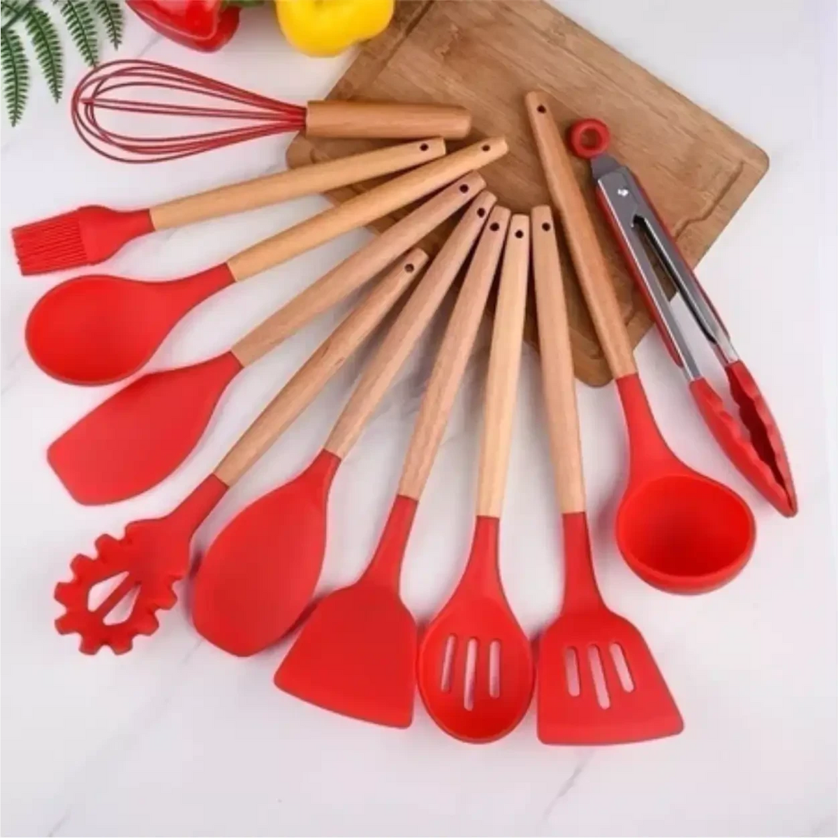 Kit de 12 utensílios de cozinha Decoricasa em silicone vermelho com cabos de madeira sobre tábua de corte