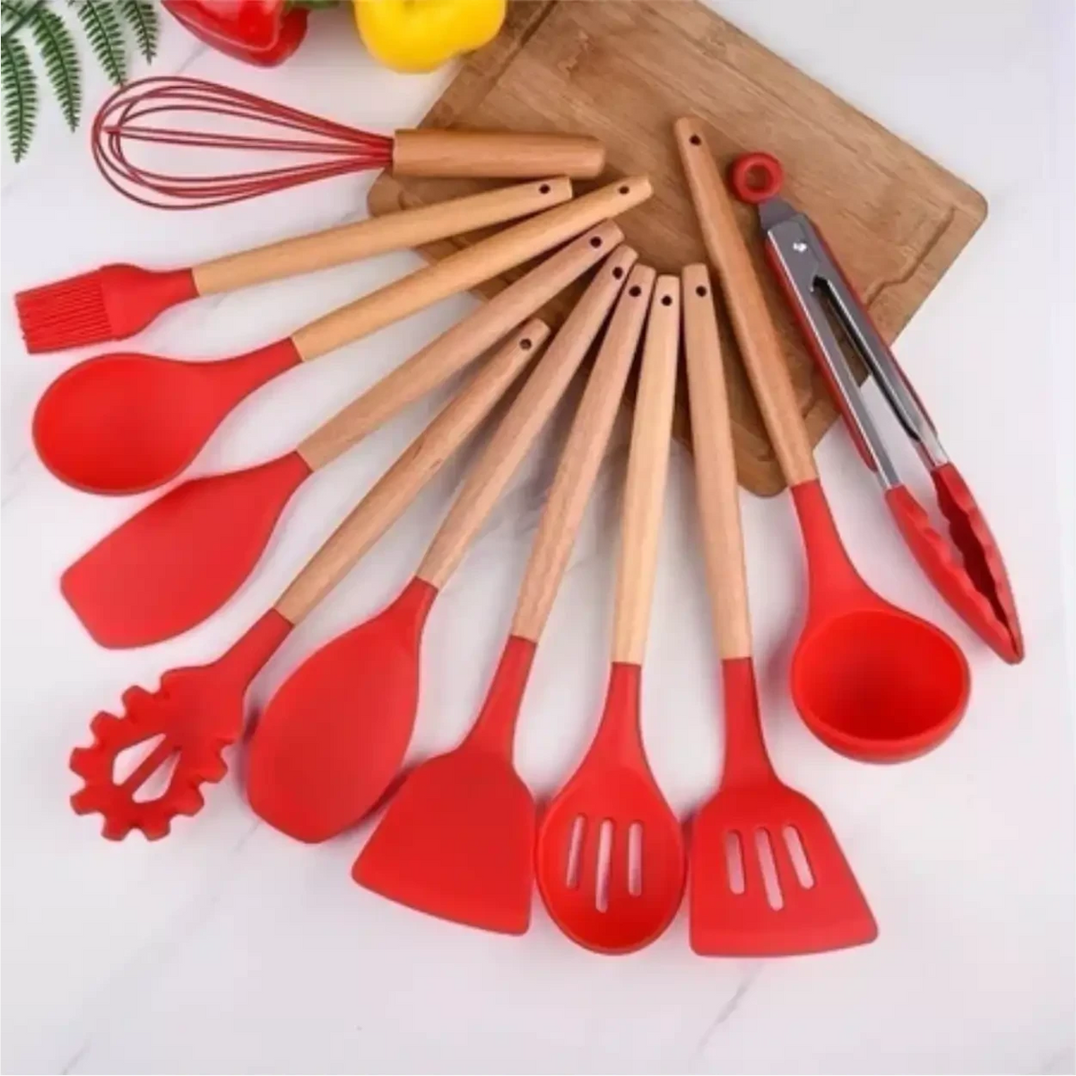 Kit de 12 utensílios de cozinha Decoricasa em silicone vermelho com cabos de madeira sobre tábua de corte