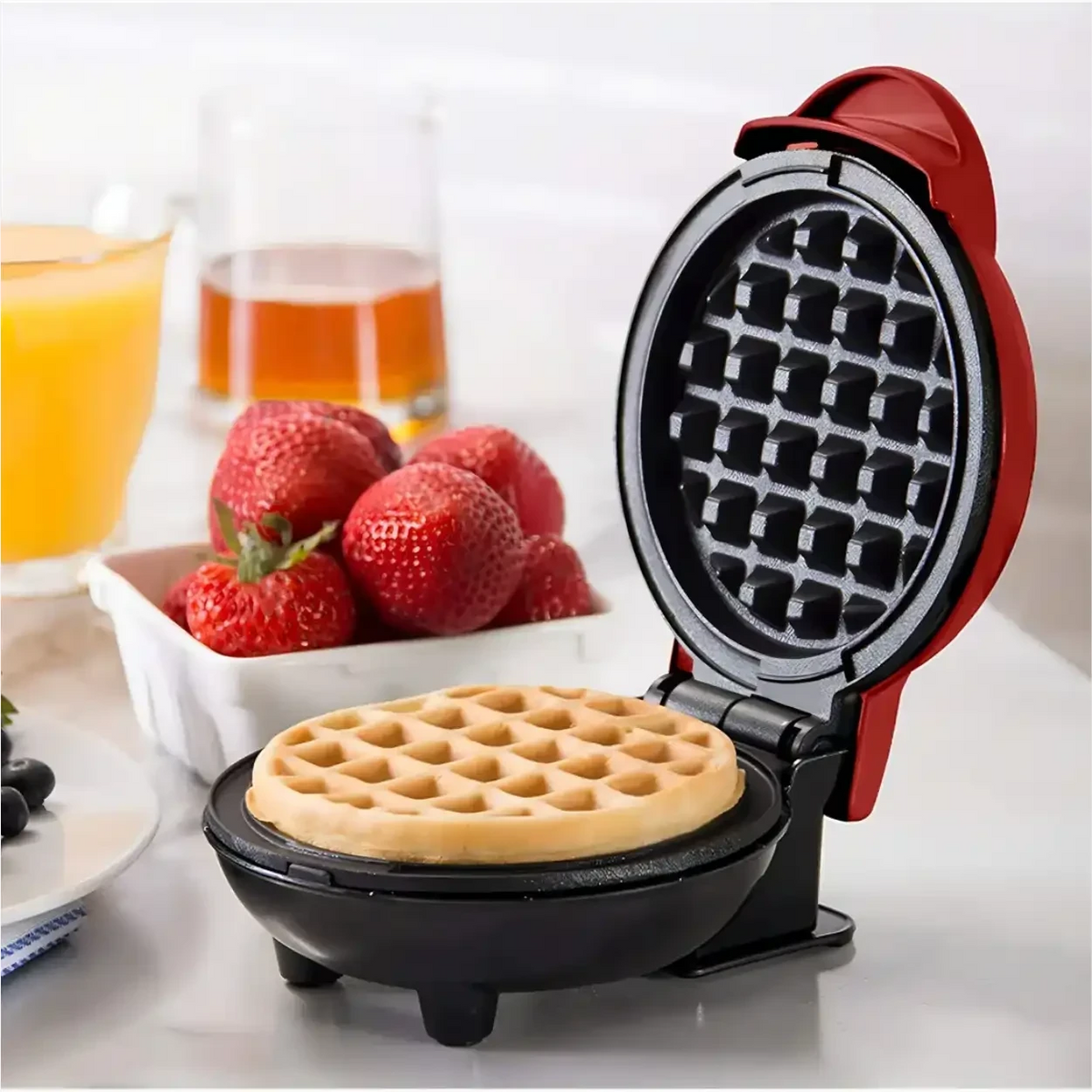 Máquina de waffle WaffleLove Decoricasa vermelha compacta com waffle dourado e morangos frescos na bancada