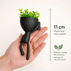 Mini vaso alpinista Decoricasa preto com planta artificial na mão de uma pessoa, medindo 11 cm de altura.