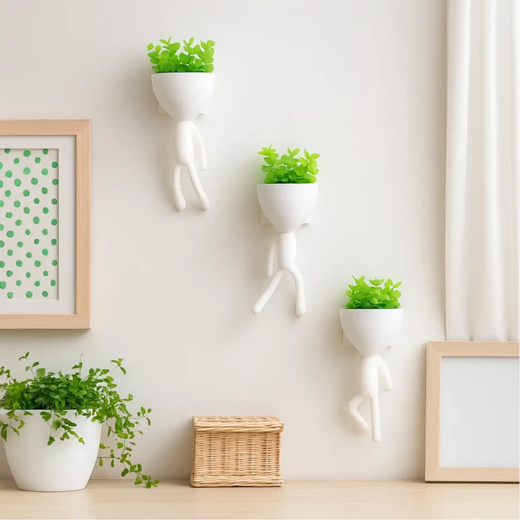 Kit com 3 mini vasos Decoricasa brancos em formato de alpinista com plantas artificiais verdes na parede
