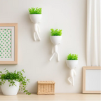 Kit com 3 mini vasos Decoricasa brancos em formato de alpinista com plantas artificiais verdes na parede