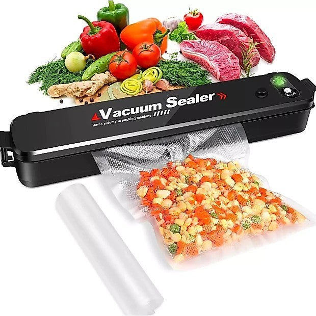 Seladora a vácuo Decoricasa FreshVac Pro preta selando saco com vegetais, com carnes e legumes frescos ao fundo.