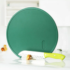 Tábua de corte redonda verde Decoricasa com suporte em pé e faca de cozinha sobre bancada branca
