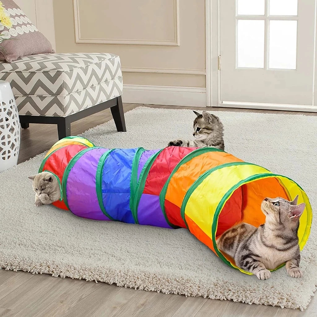 Túnel labirinto dobrável e colorido para gatos da Decoricasa, com três gatinhos brincando em uma sala de estar.
